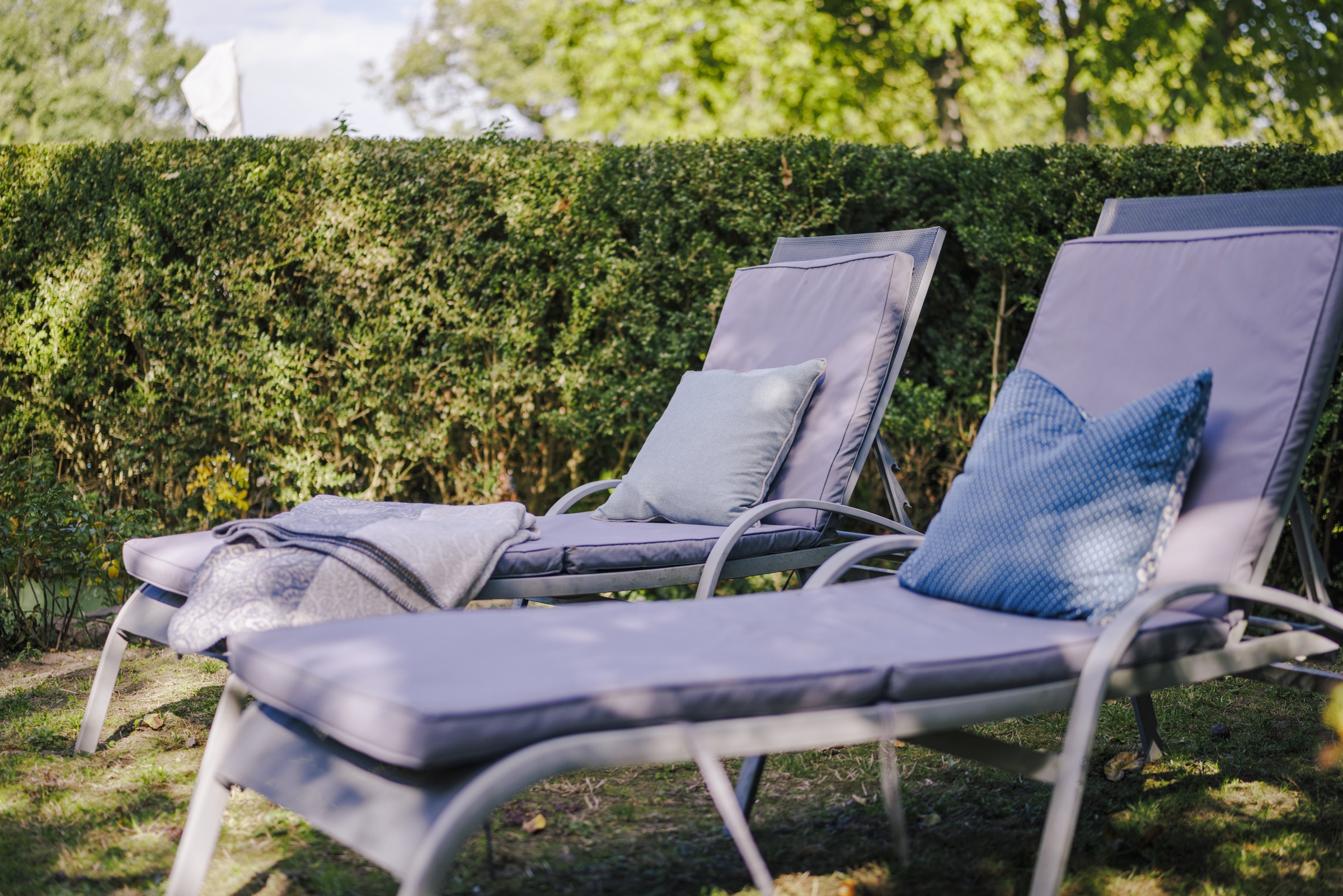 Zwei Sonnenliegen mit blauen Kissen
