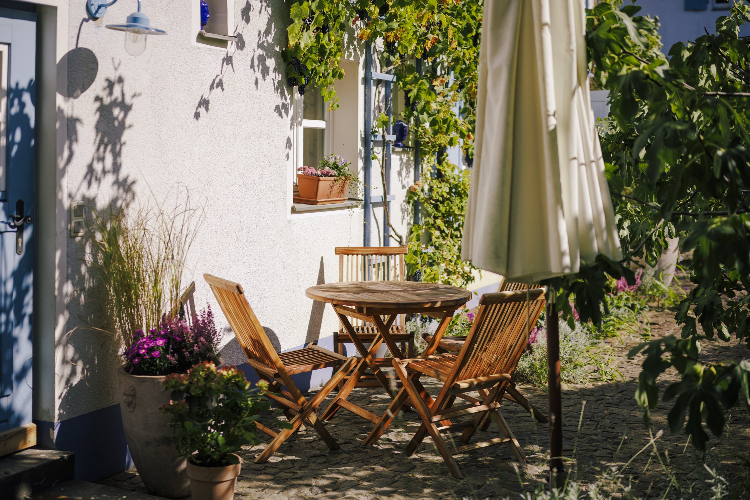 Terrasse mit Holztisch und Sonnenschirm